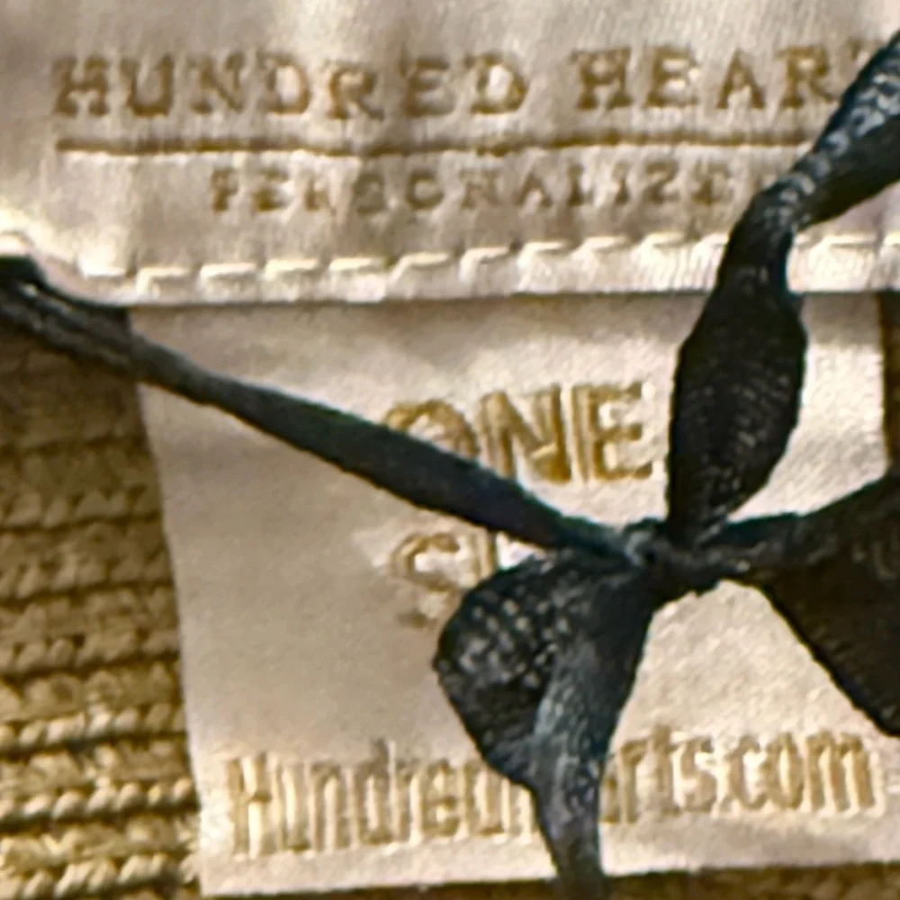 Hundred hearts straw oversized sun hat with black poms around the crown